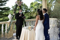 a bride and groom exchange vows on a balcony