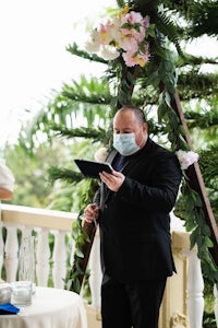 a man in a suit reading a wedding vows